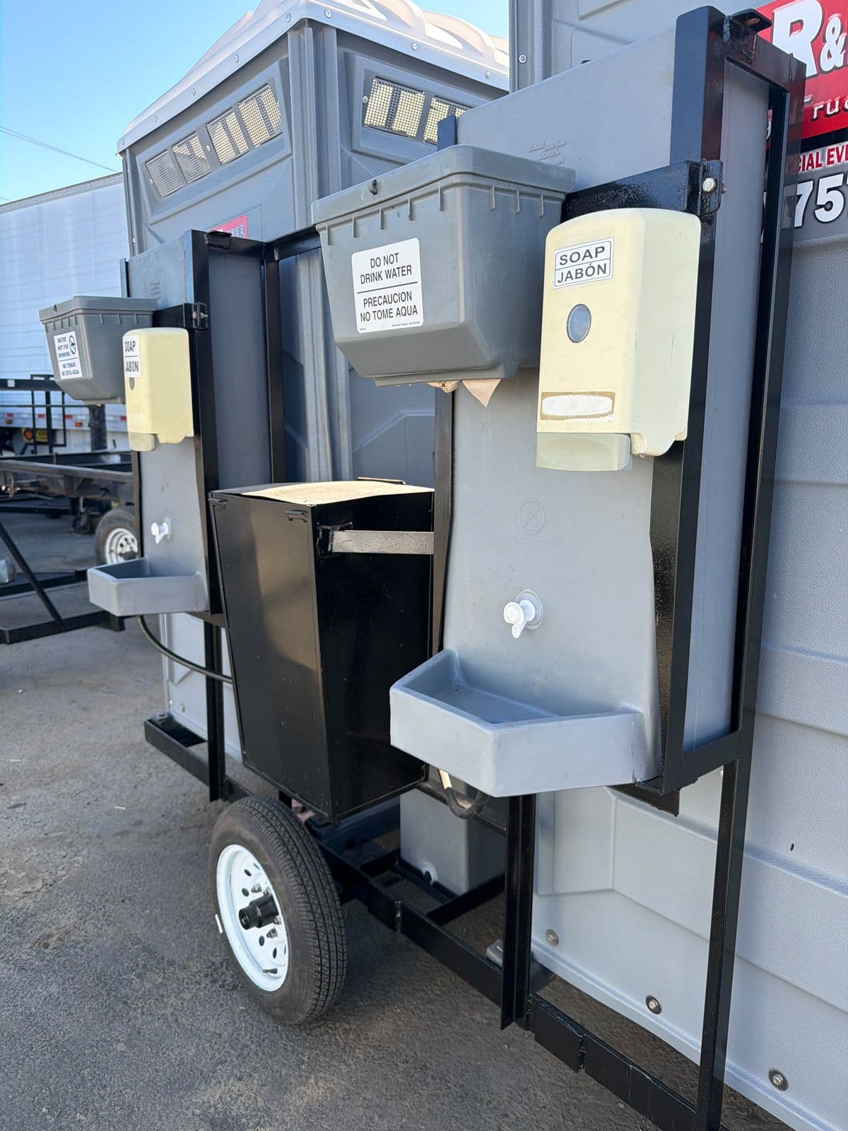 Trailer hand-wash station with soap and paper towel dispensers and a bilingual do-not-drink-water sign