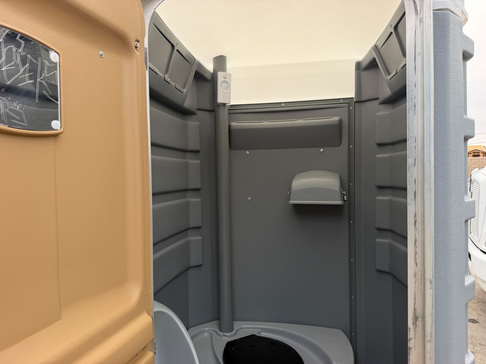 Clean interior of a standard portable restroom showing the toilet seat